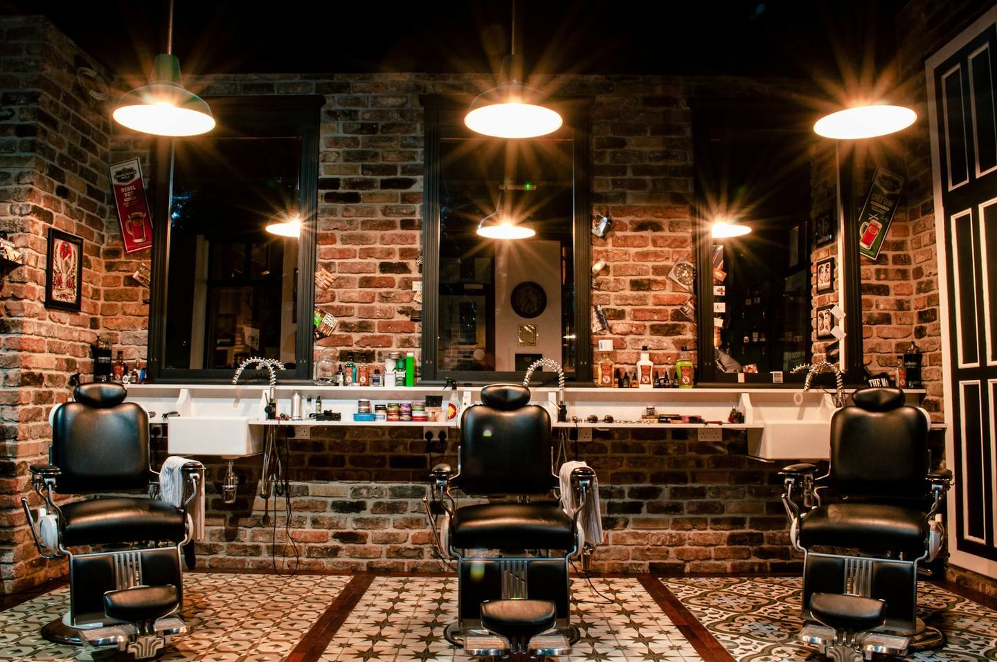 A warm barbershop with leather chairs and pendant lights