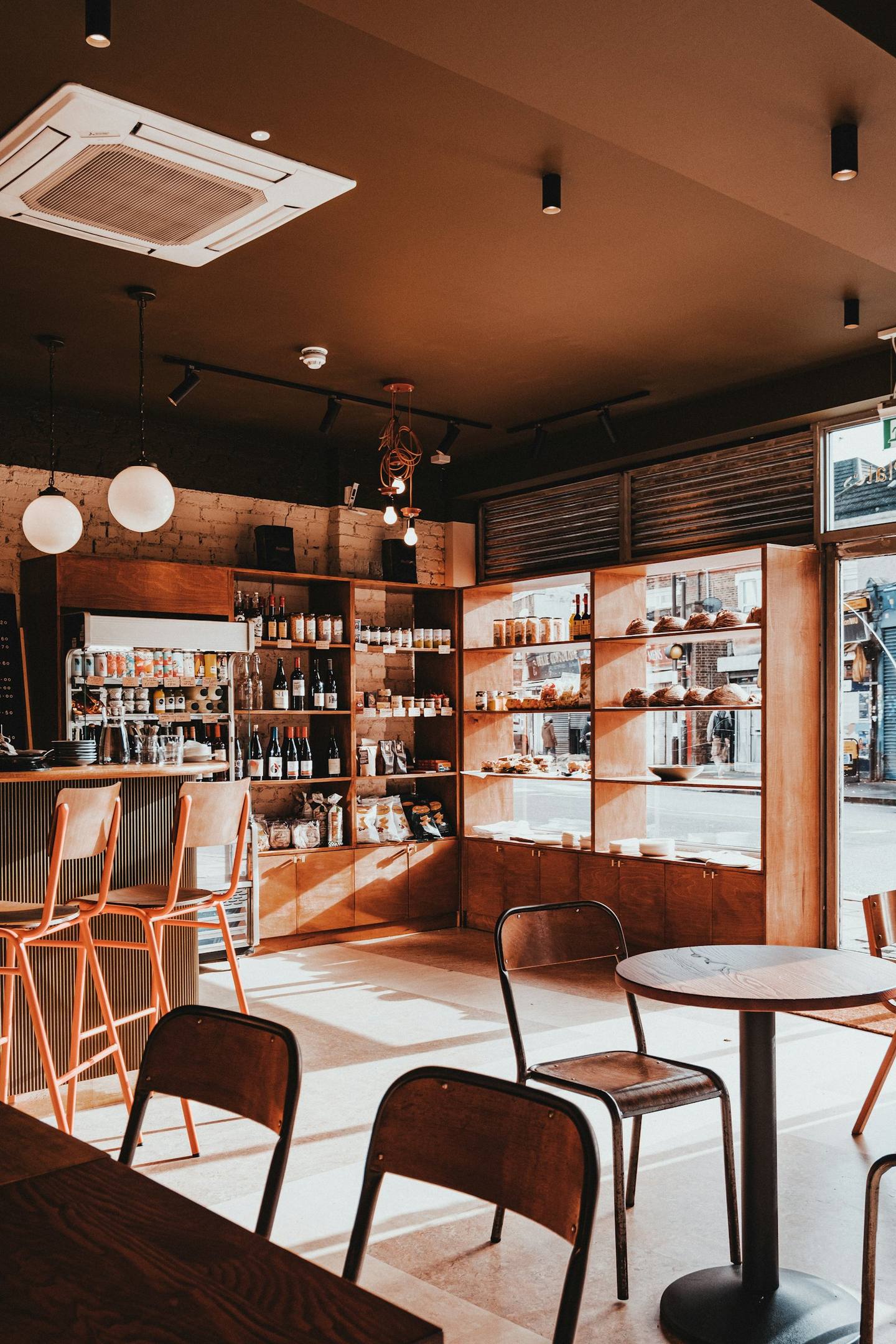 A warm café interior with wooden shelves and pendant lights