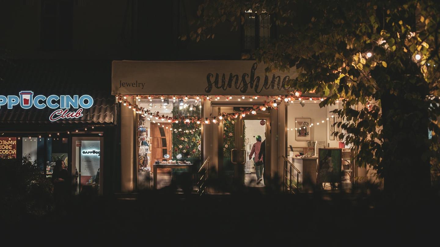 A local shopfront glowing with string lights at night