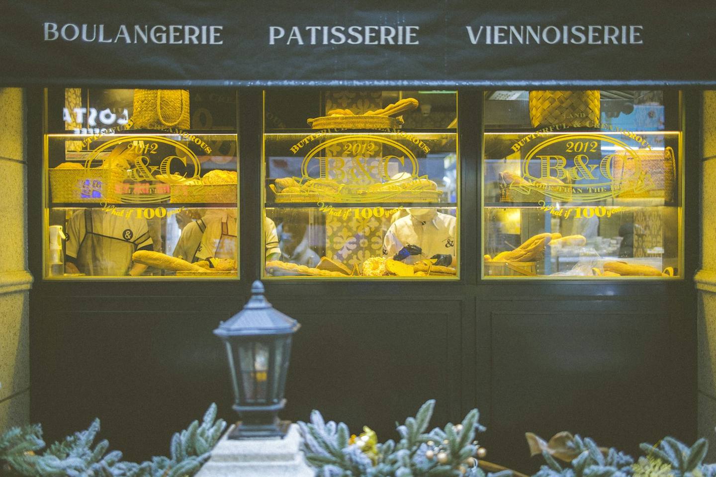 A boulangerie window glowing at night
