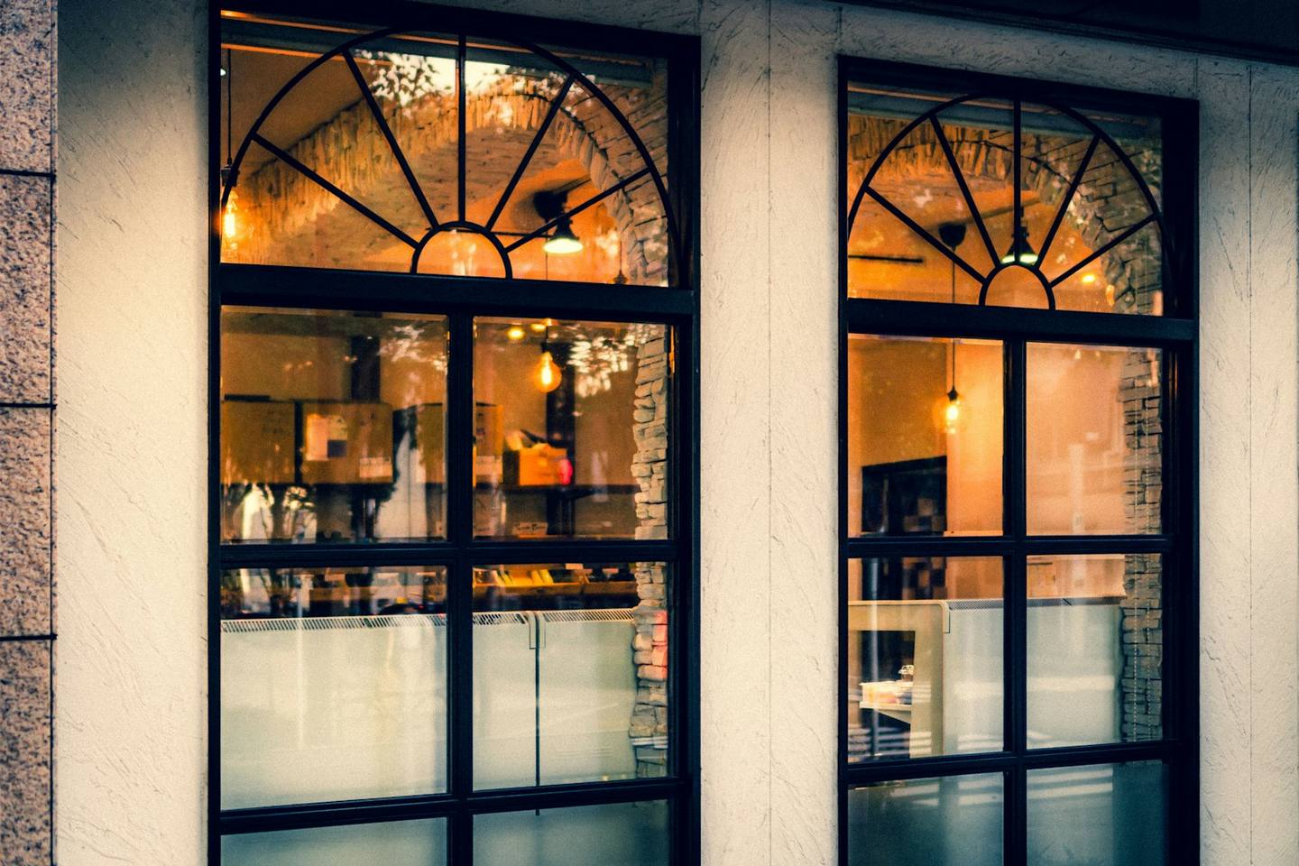 Arched shop windows glowing warmly at night