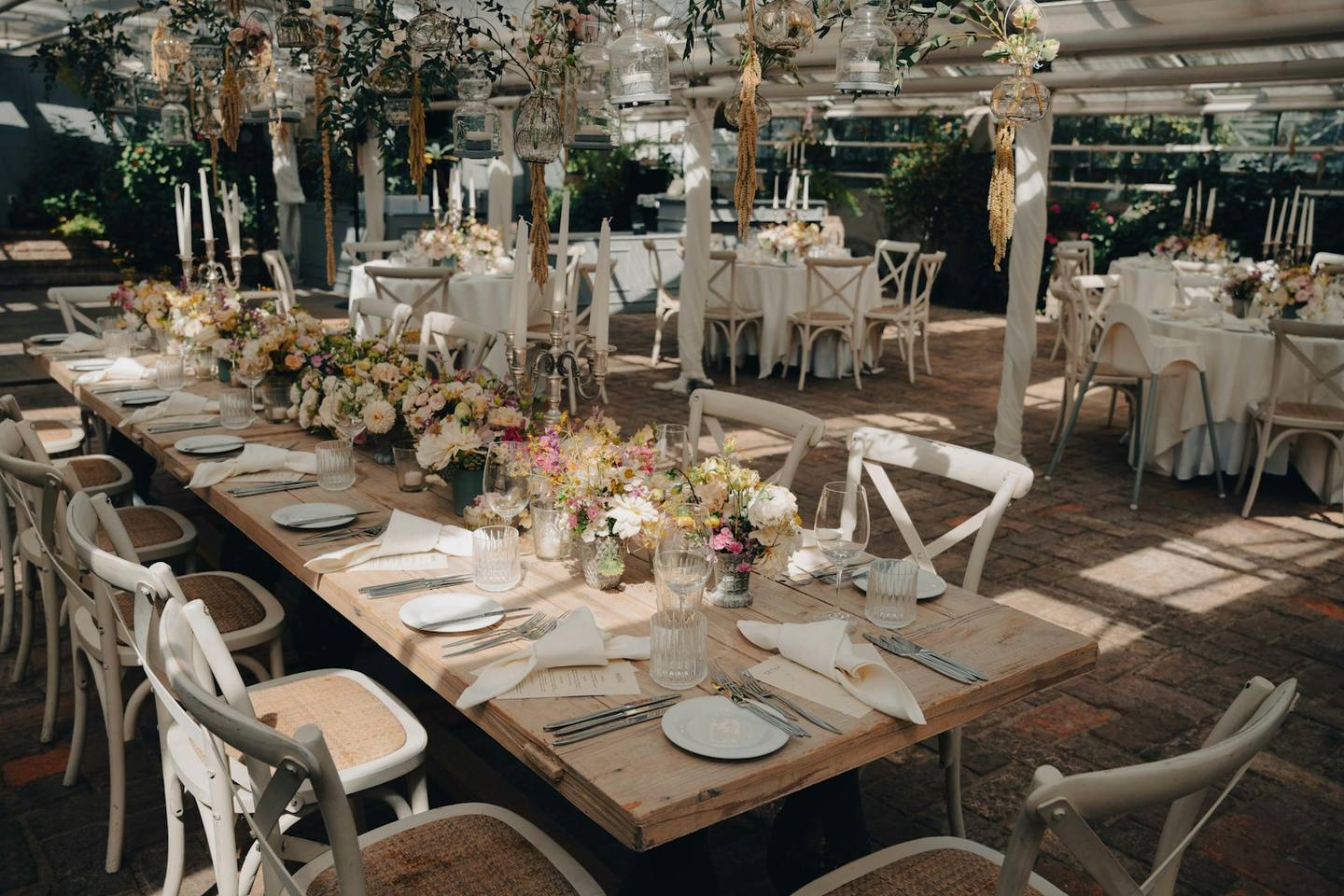 A garden reception with long tables set with flowers