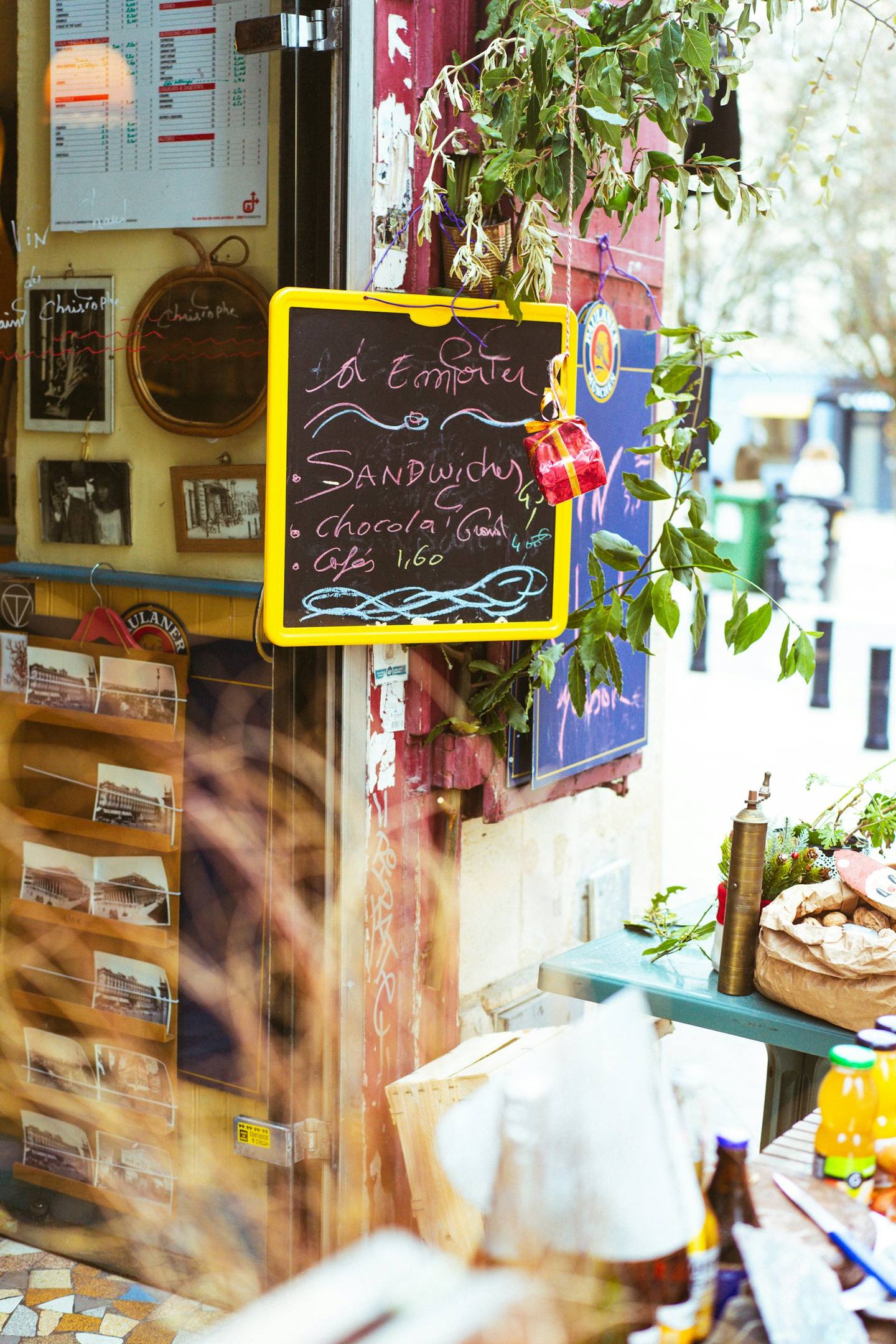 A colourful café wall with a chalkboard menu and postcards