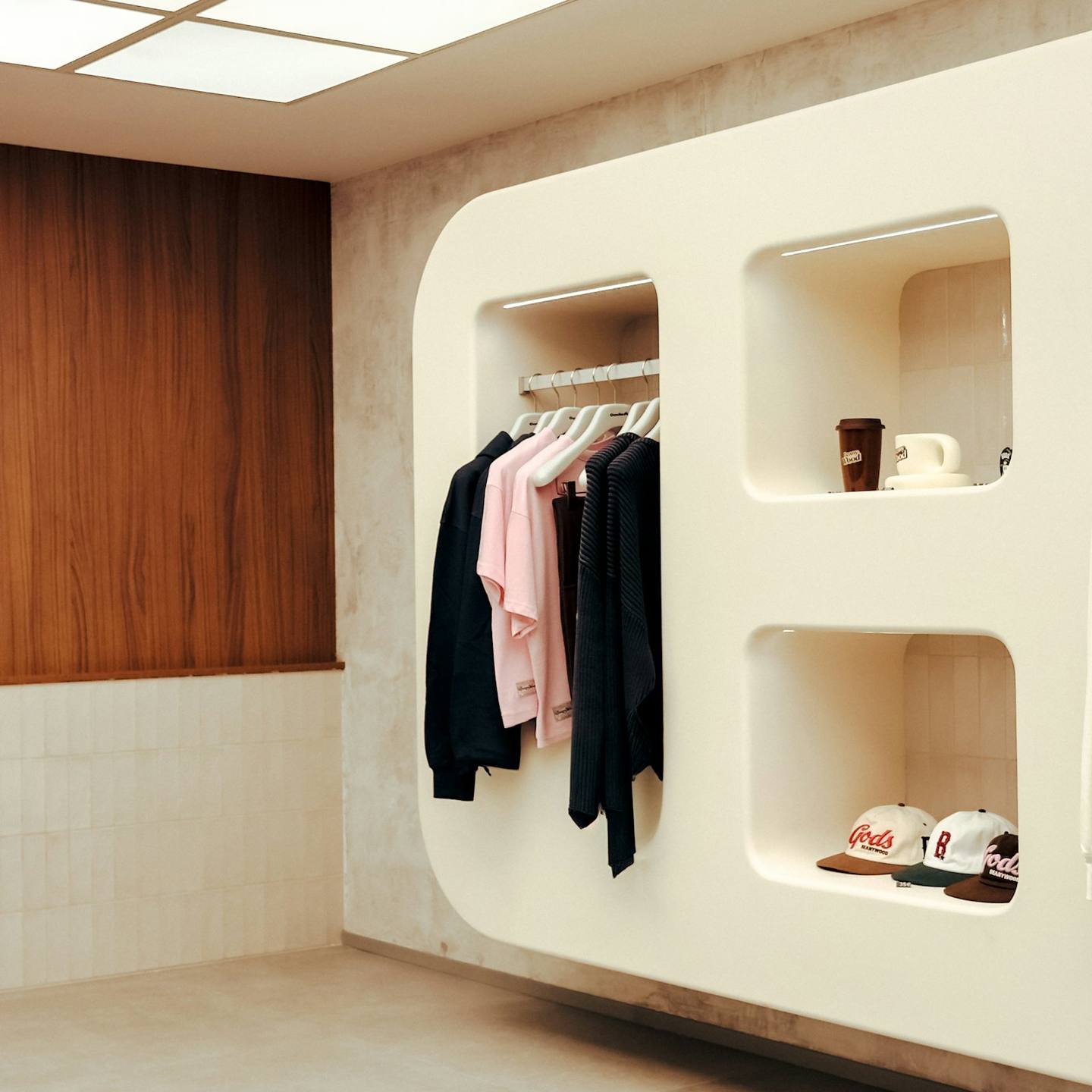 A clean, modern shop display with clothing and caps