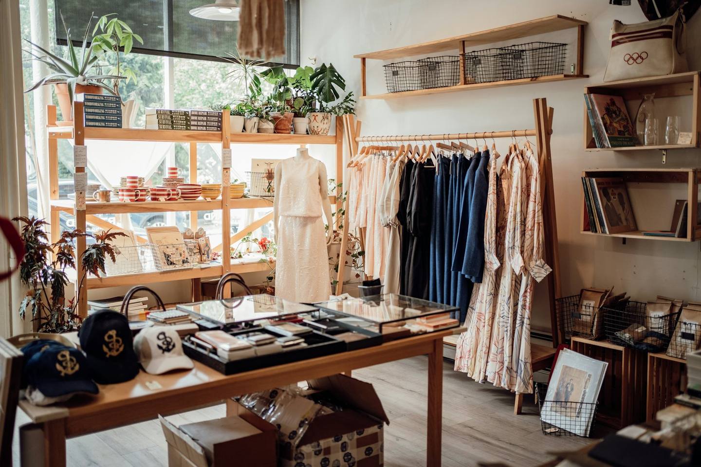 A sunny boutique with clothing racks and plants