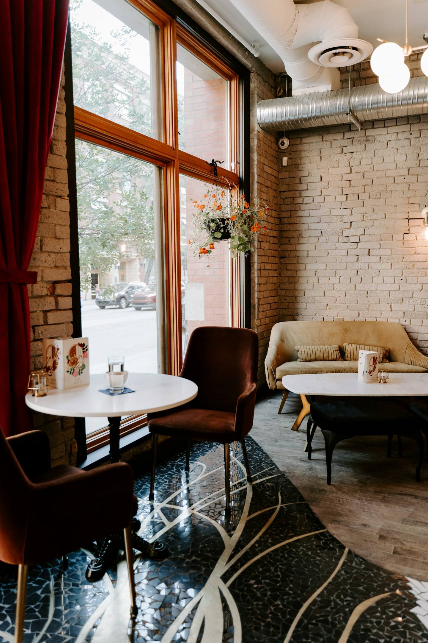 A sunny café corner with armchairs and a brick wall