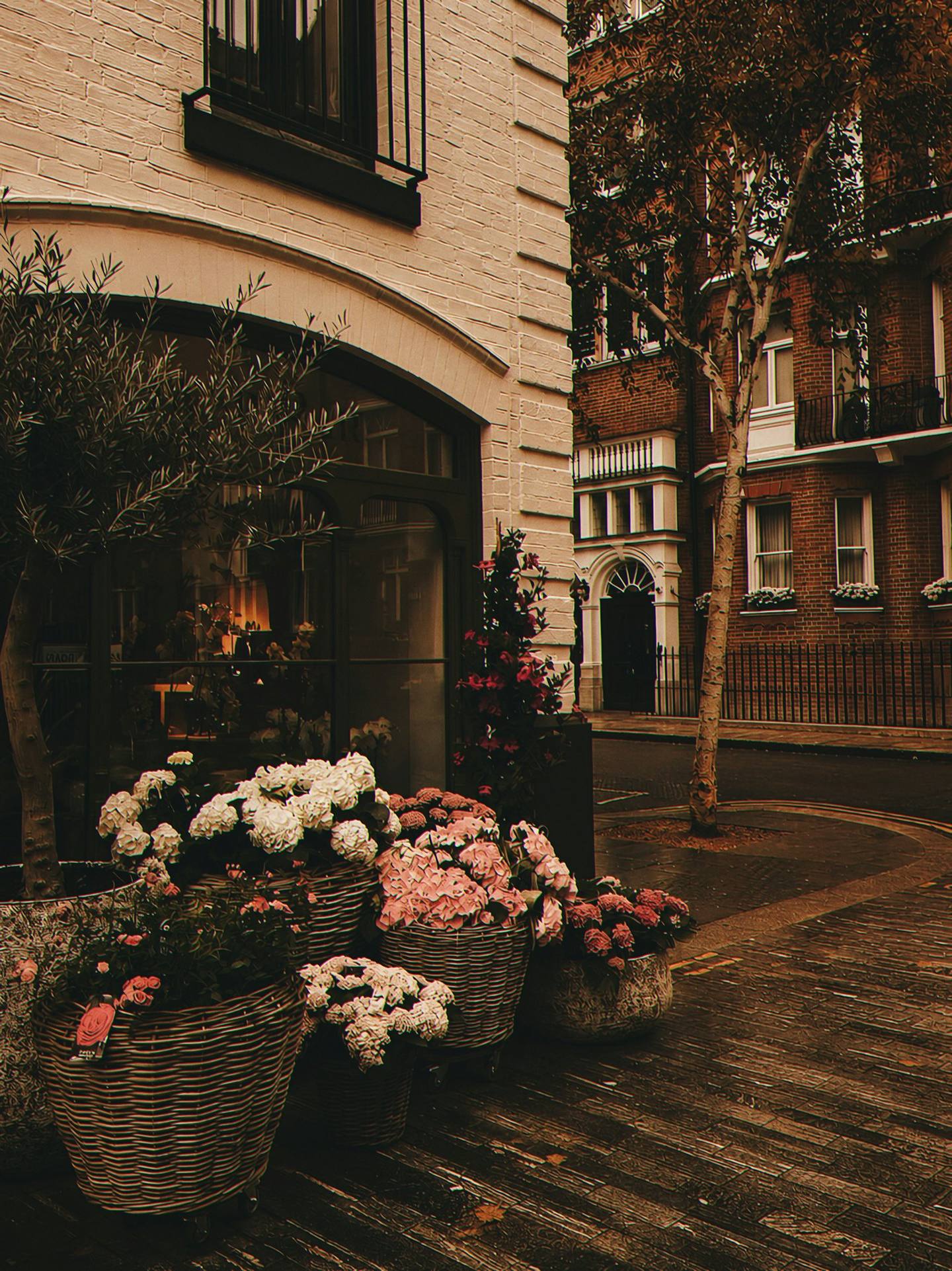 Baskets of hydrangeas outside a warm brick shopfront