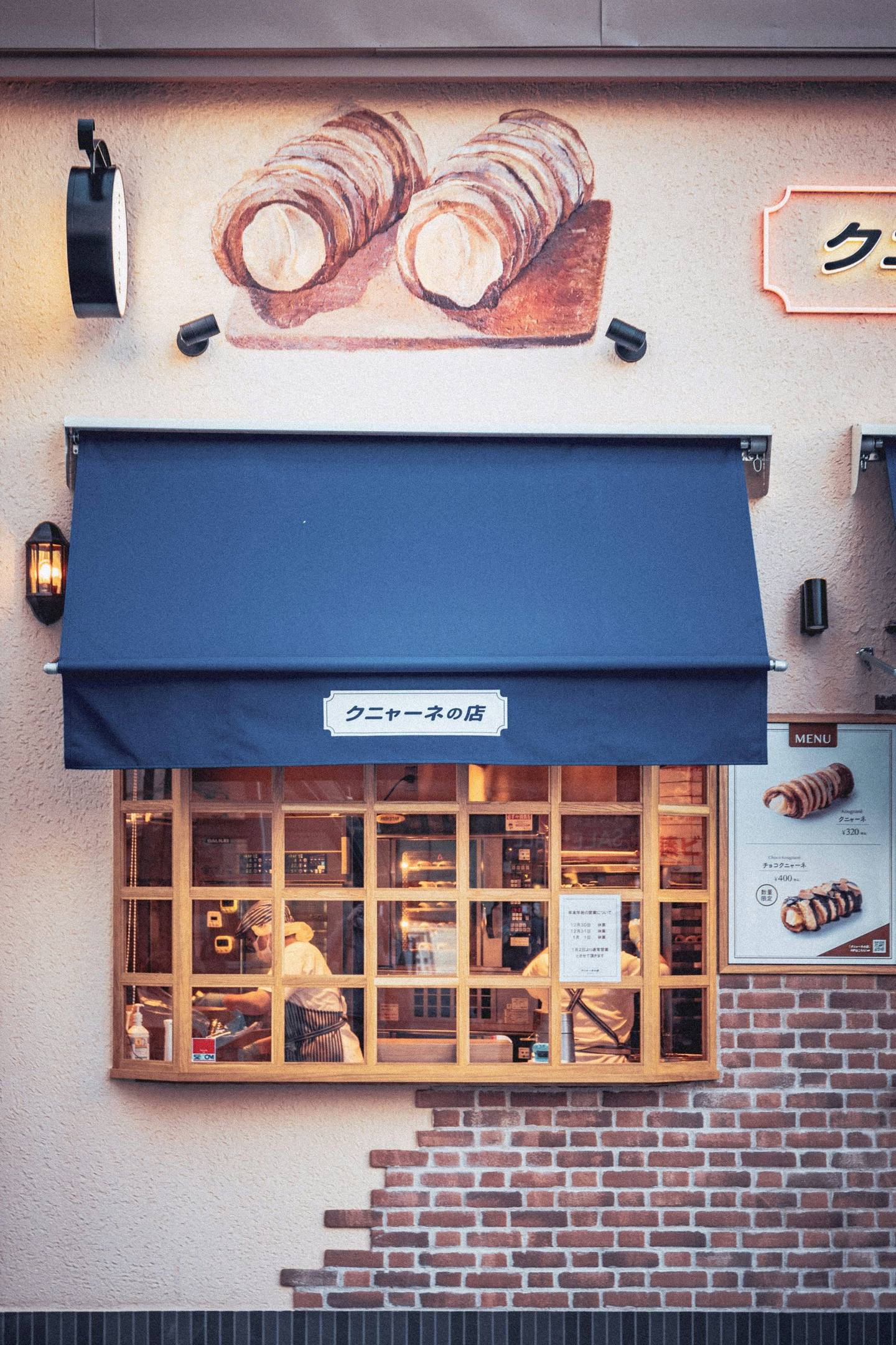 A bakery window under a navy awning