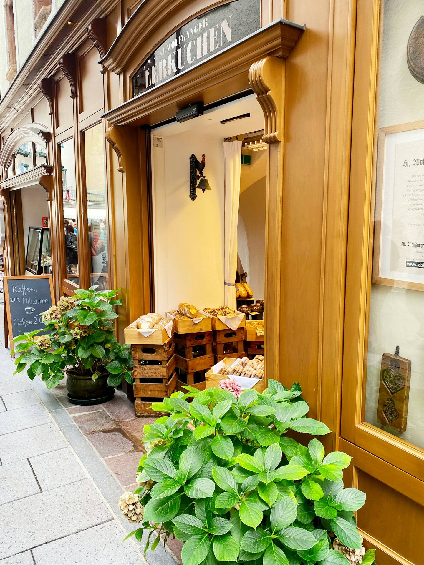 A doorway with crates of fresh bread and potted hydrangeas