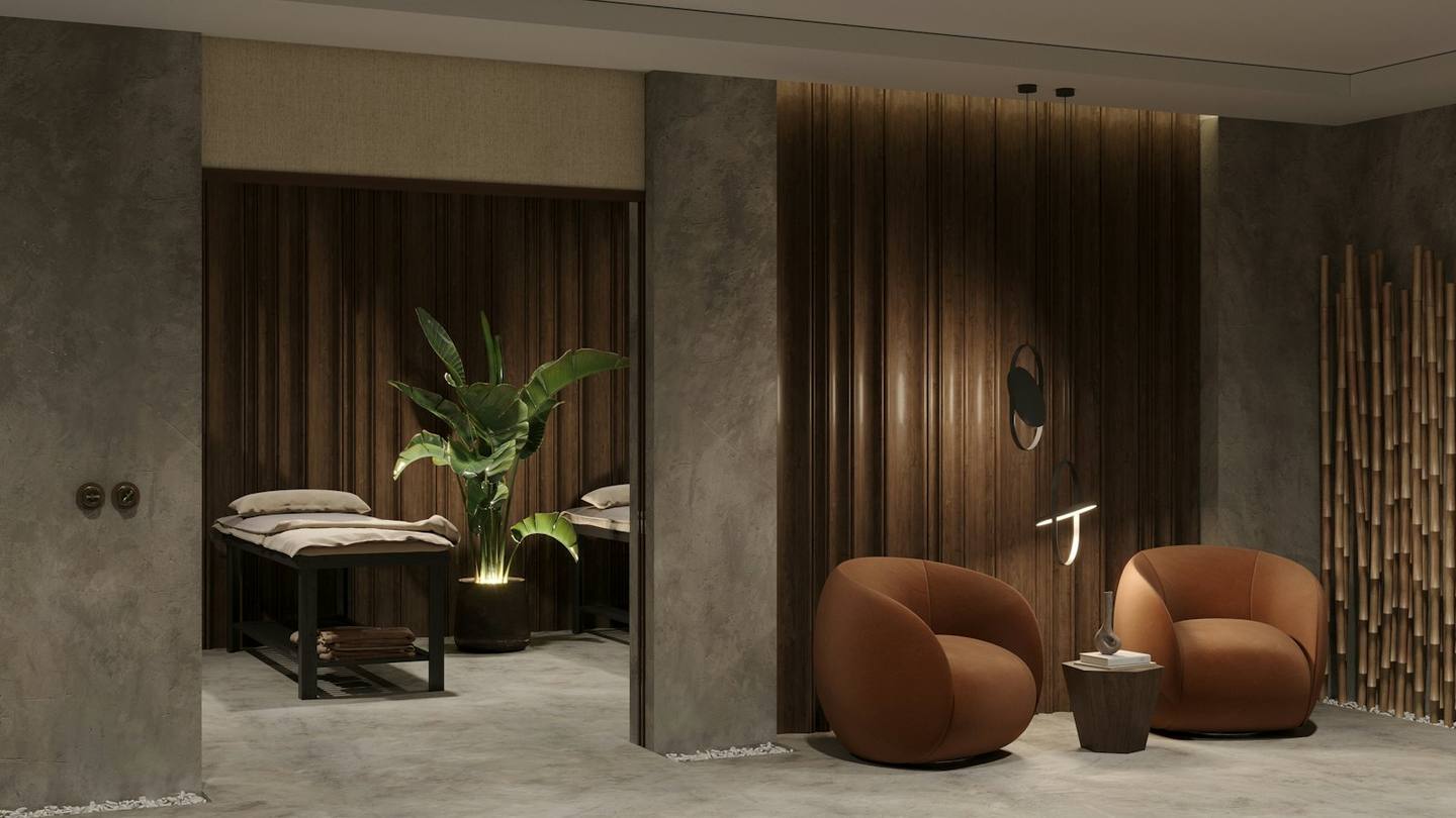 A treatment lounge with a massage bed and armchairs